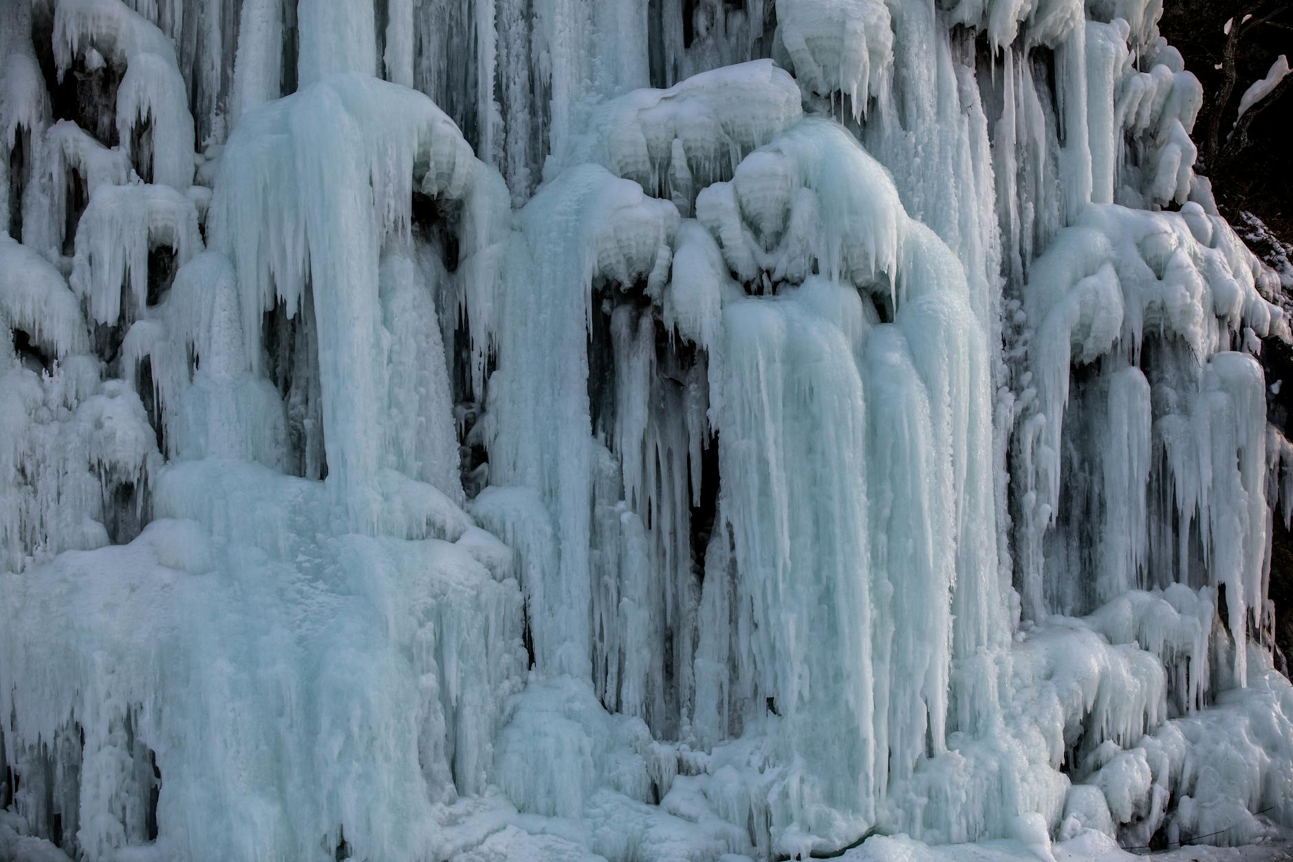 Zamarznięty wodospad zimą z efektownymi formacjami lodu