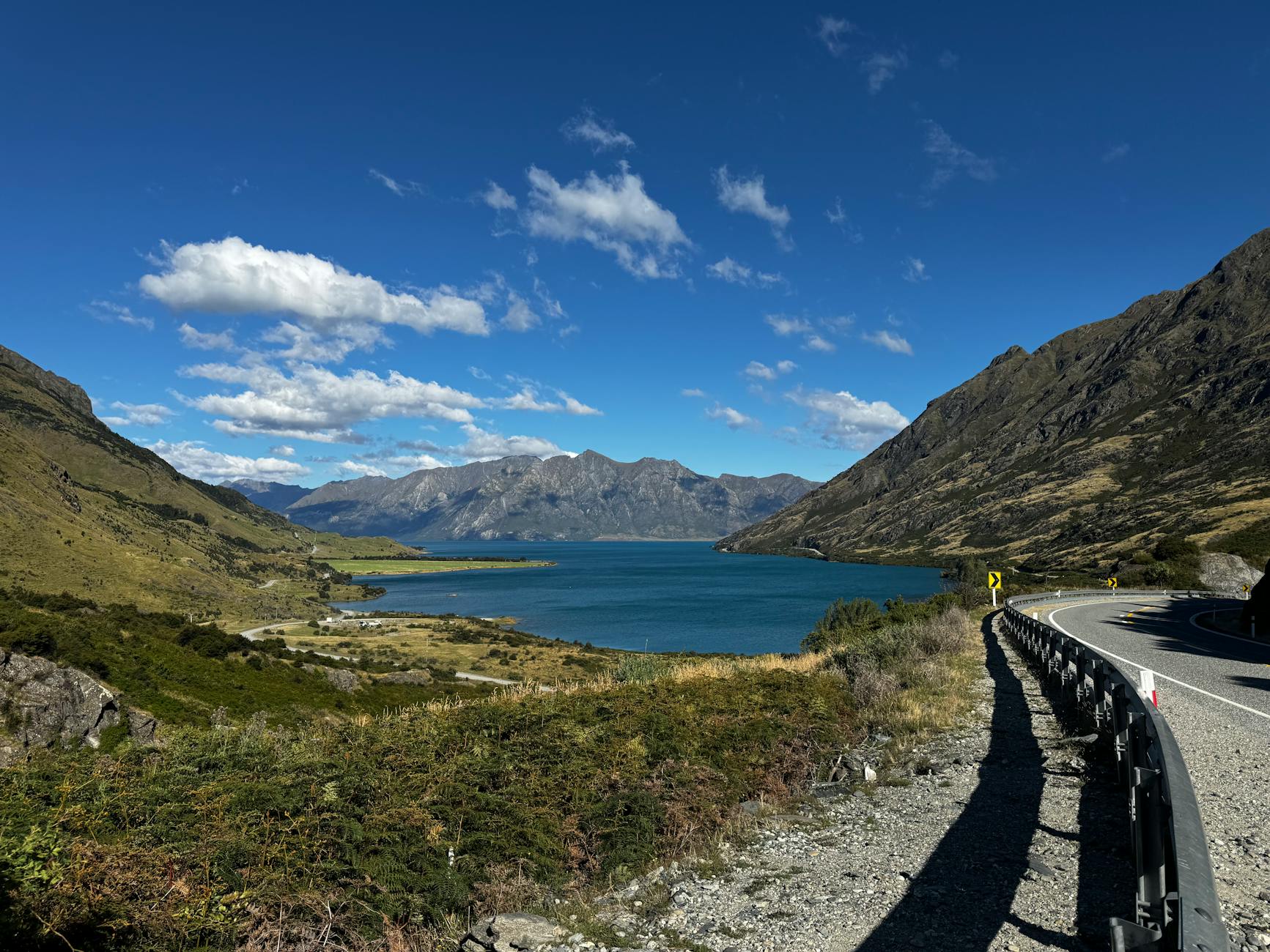 Którędy jechać z Auckland do Queenstown: szczegółowy plan trasy z noclegami i atrakcjami Jezioro Hawea otoczone górami w słoneczny dzień, trasa z Auckland do Queenstown