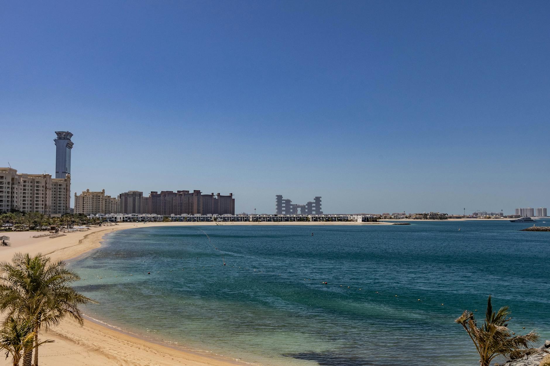 Plaża na Palm Jumeirah w Dubaju z widokiem na nowoczesne wieżowce