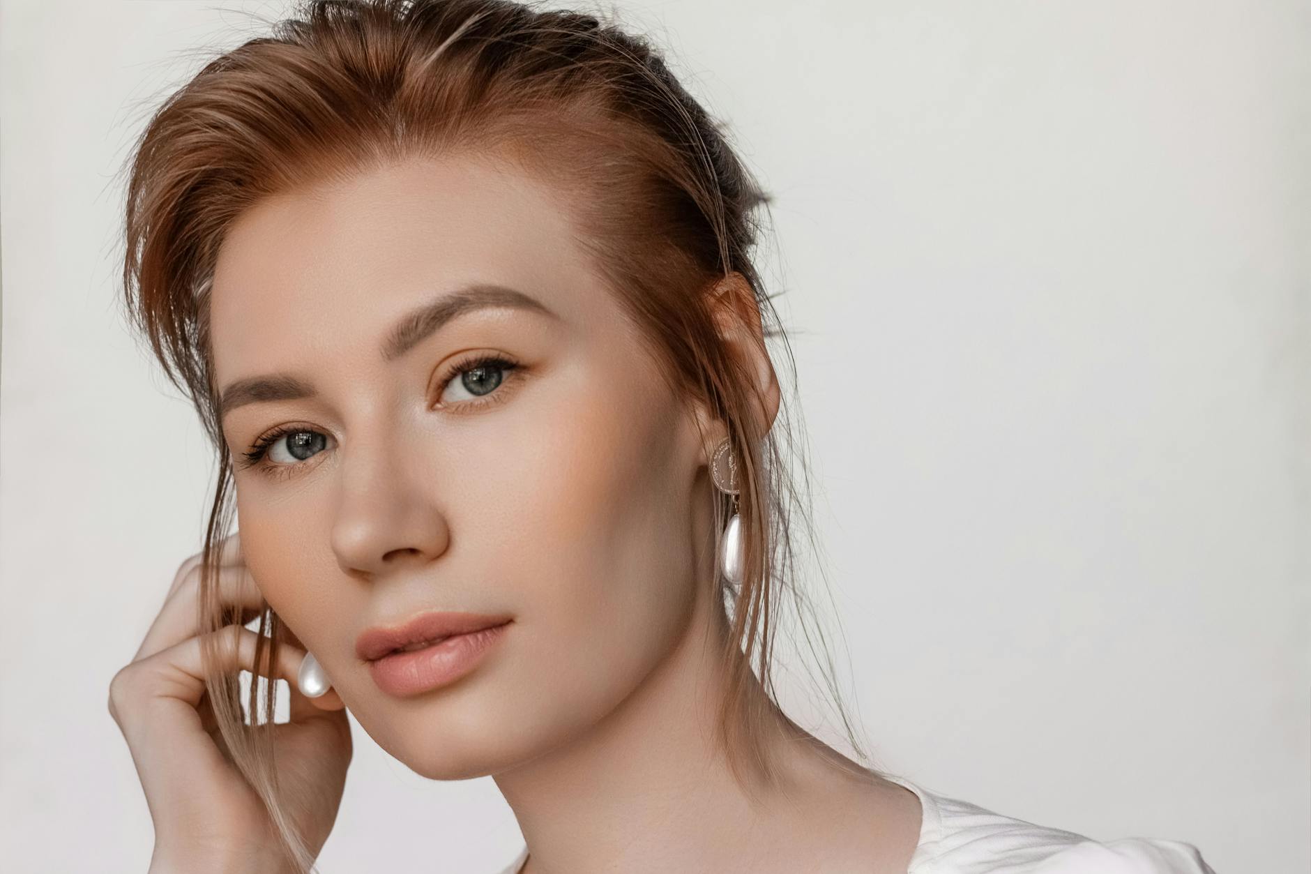 Portret młodej kobiety z delikatnym, naturalnym makijażem w studiu