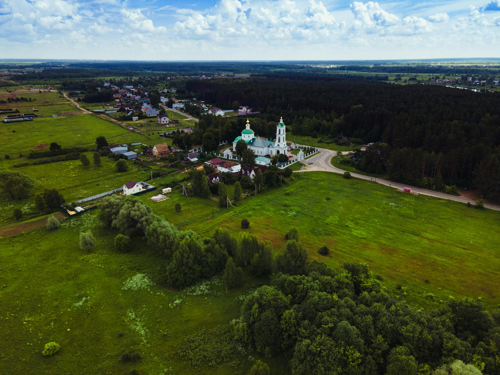 Barokowy kościół w rosyjskiej wsi otoczony zielonymi polami Barokowy kościół w rosyjskiej wsi otoczony zielonymi polami
