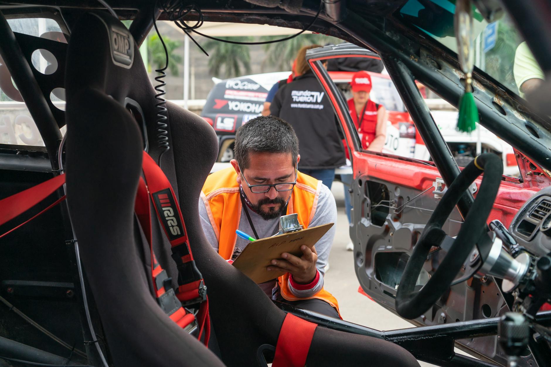 Jak kupić używane Porsche 911: poradnik krok po kroku dla świadomego kierowcy Mężczyzna z notatnikiem ogląda wnętrze sportowego samochodu