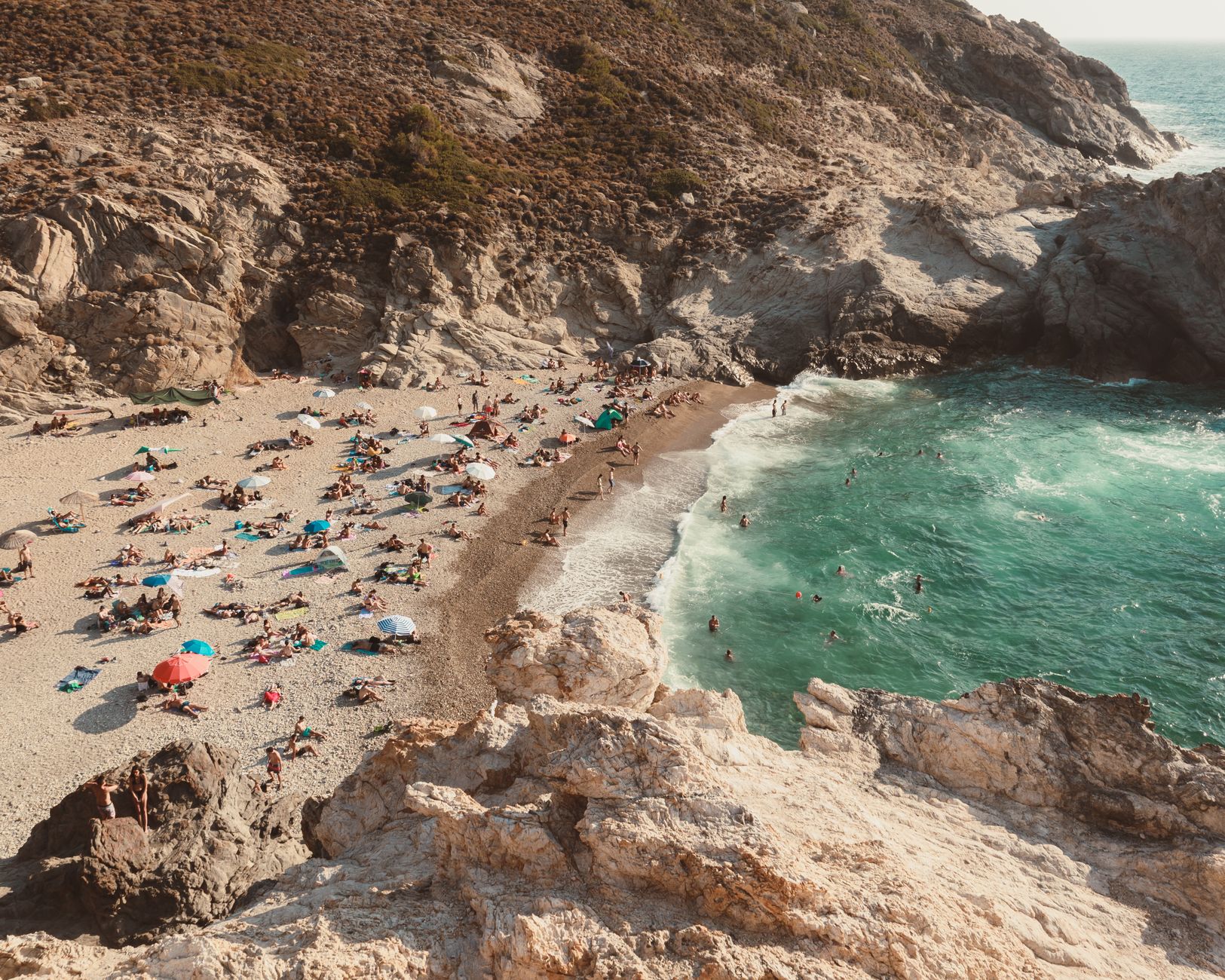 Tłoczna plaża nad turkusowym morzem w południowej Europie
