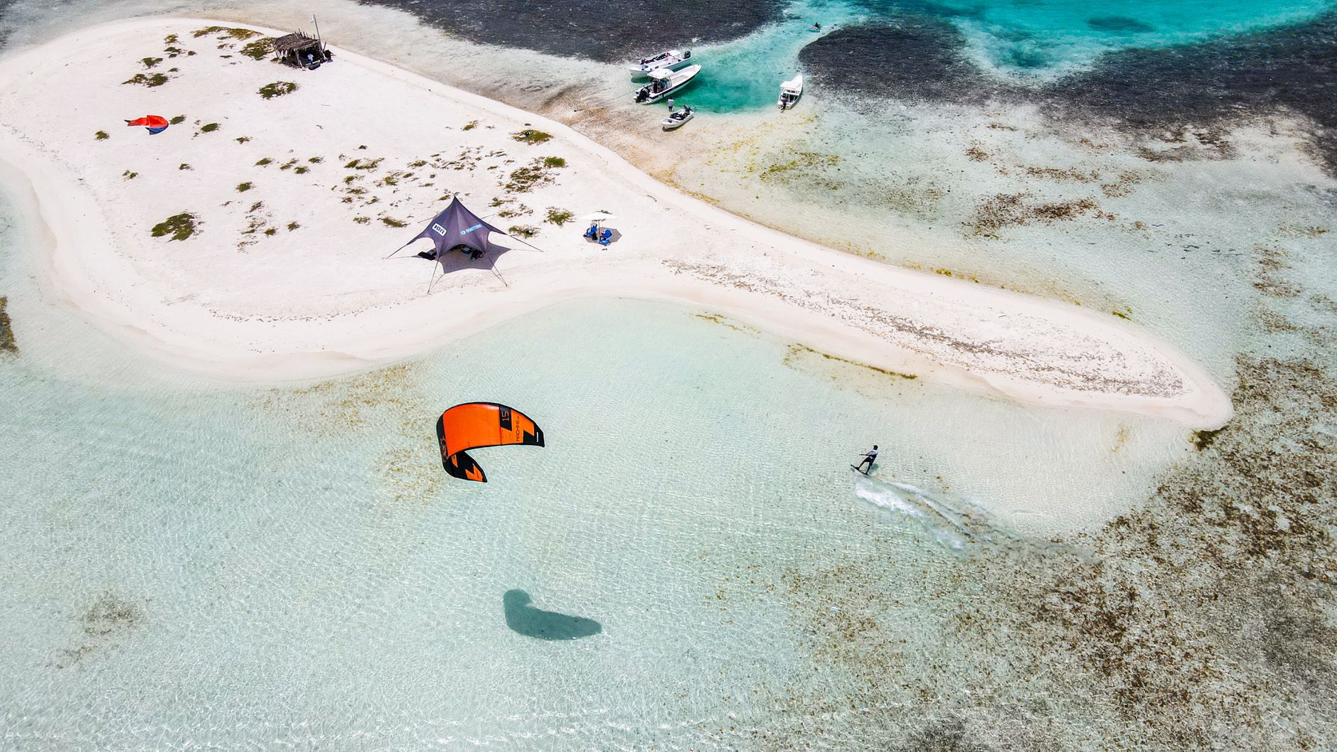 Kitesurfer na turkusowej wodzie przy piaszczystej plaży Dominikany