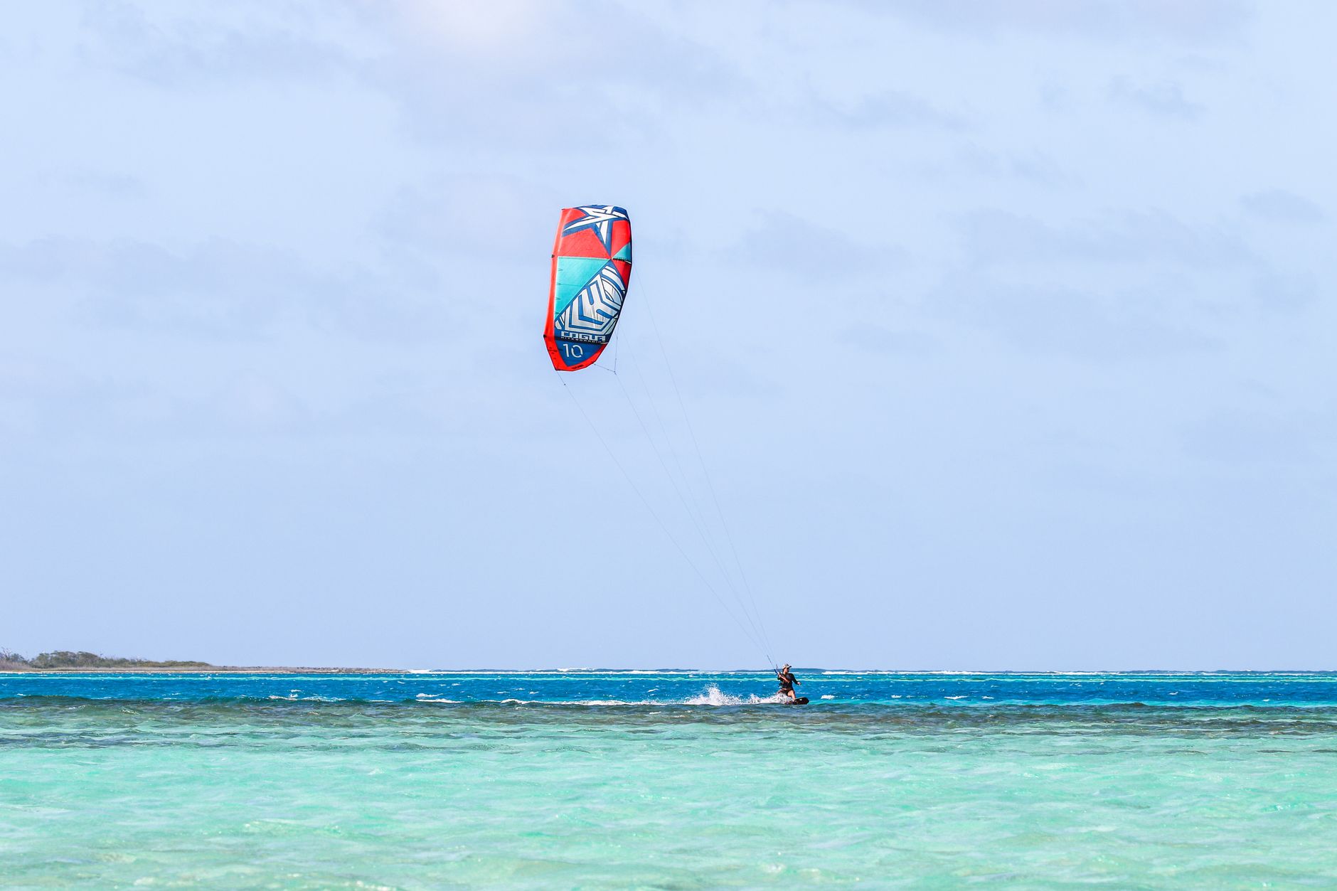 Kitesurfer na turkusowej wodzie u wybrzeży Dominikany Kitesurfer na turkusowej wodzie u wybrzeży Dominikany