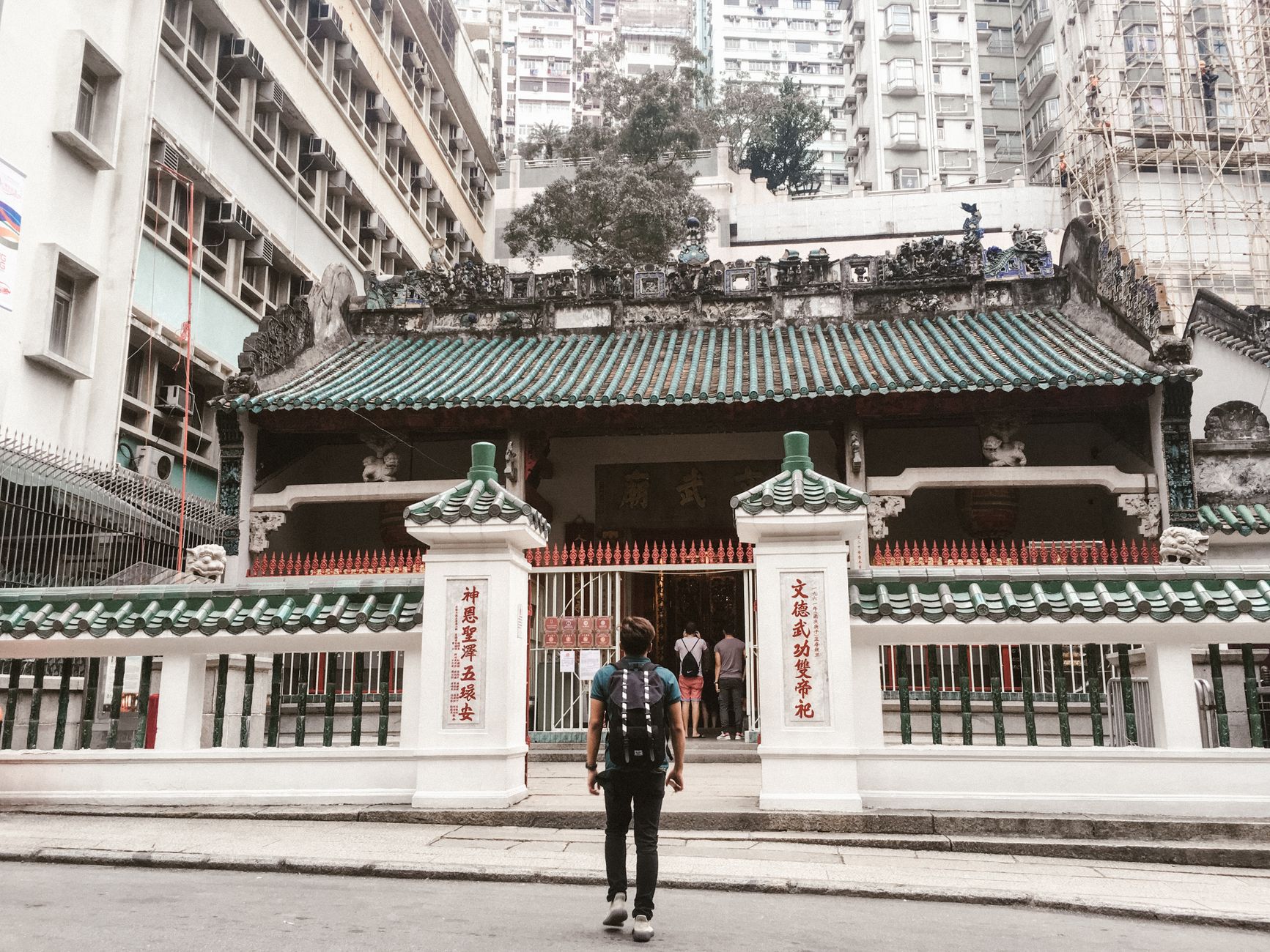 Wyspa Lantau i Tian Tan Buddha: jednodniowa wycieczka z Hongkongu krok po kroku Backpacker przy świątyni Man Mo na tle drapaczy chmur Hongkongu